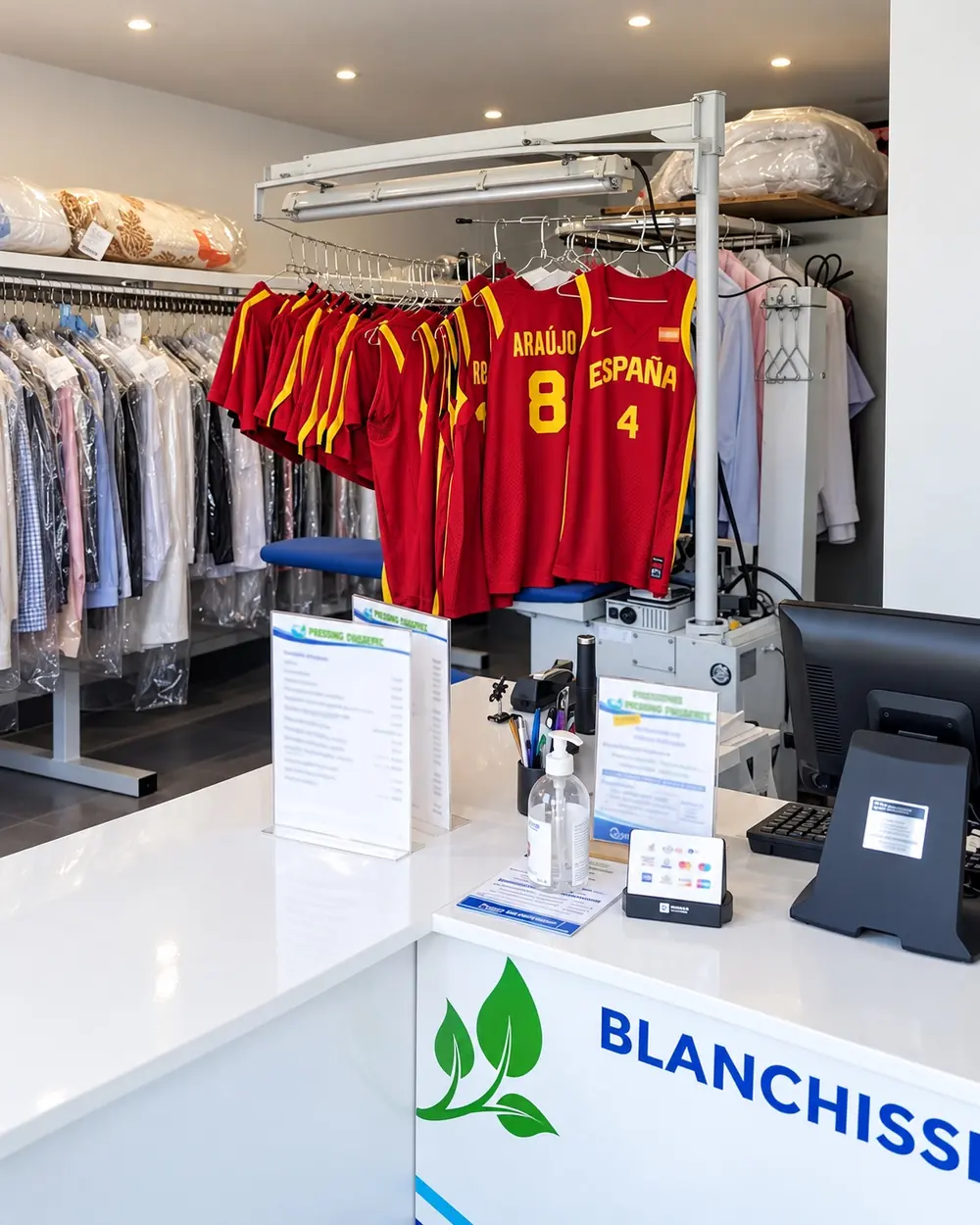 Comptoir d'accueil et vêtements sous housse à l'intérieur du Pressing Aquanett